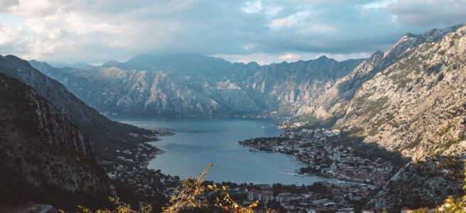 Breathtaking aerial view of the Bay of Kotor surrounded by dramatic mountains under a cloudy sky.